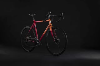 Orange-red fade All-City Zig Zag disc road bike with Whisky wheels, three-quarter front view in the studio.