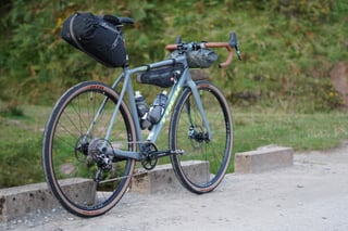 Three-quarter view of the bikepacking-ready Trek Crockett 7 with seat pack, frame bag and bar bag on a gravel track.