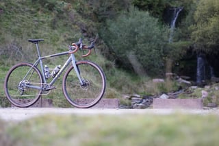 James Heaton's unloaded Trek Crockett 7 side-on below a waterfall and scrub-covered hillside in the Welsh Valleys.