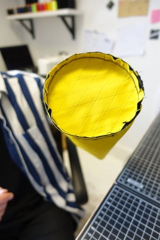 Looking into the yellow X-Pac lined end of a half-built Straight Cut bar bag, with a cutting mat beside it.