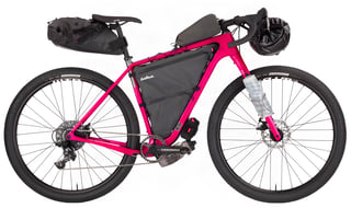 Pink Salsa Cutthroat Apex 1 in bikepacking trim with frame bag, saddle pack and handlebar roll, studio shot.