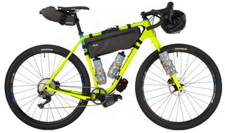Lime green Salsa Cutthroat set up for a sub-24 overnighter with frame bag, bottles, seat pack and bar roll.