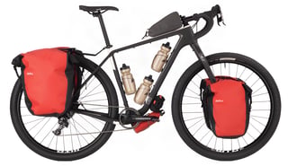Black Salsa Cutthroat in touring trim with red panniers front and rear and three bottles on the frame.