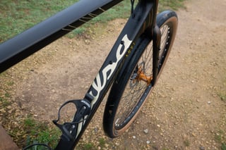 Salsa Warroad downtube with cream Salsa logo and a bottle cage, with the 650b front tyre behind.