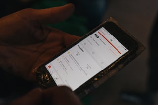 Rider's hand holds a phone showing Strava segment results from the Scope Backyard Breakaway.