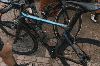 Mud-caked blue and gold road bike with bottles and Scope wheels, parked after the Backyard Breakaway ride.