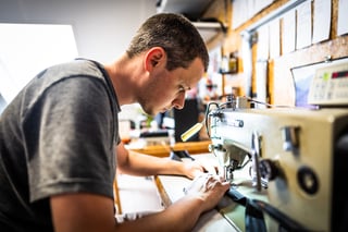 Detour Studio maker stitching a bikepacking bag at a sewing machine in the workshop in Arnhem, the Netherlands.