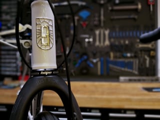 Cloud 9 Cycles frame with a gold badge on the head tube and a Hope headset, in front of a workshop tool wall.