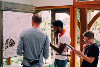 Riders study the pinned master map of checkpoints inside a timber building at the Low Key Lakes Weekender.