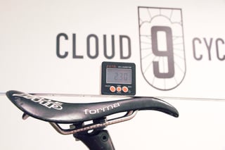 Digital inclinometer on a saddle during a bike fit, with the Cloud 9 Cycles logo on the wall behind.