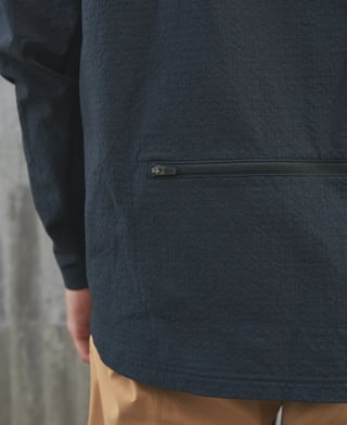 Zipped rear pocket at the hem of the black POC Mantle thermal hoodie, seen from behind.