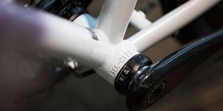 Threaded bottom bracket cup on a white All-City Cosmic Stallion frame with the crank arm alongside.