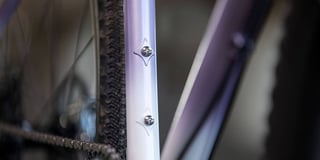 Rack and mudguard mounting bosses on a white-to-purple fade Cosmic Stallion seat stay.