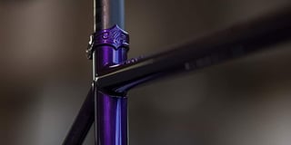 All-City embossed seat collar and top tube junction on a purple Cosmic Stallion frame.