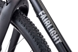 Silver Fairlight logo on the black downtube of the Secan, beside the knobbly front tyre.