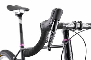 SRAM Force shifter lever and black bar tape on the Fairlight Secan, with a purple Hope headset behind.