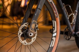 Close-up of the A.T.E.R. front disc brake, rotor and fork end with gold-and-rust painted detail, beside an ENVE rim.