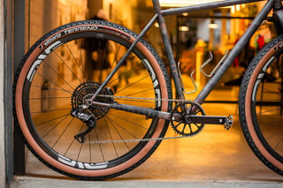 Rear wheel and Shimano GRX Di2 drivetrain of the Belle Cycles A.T.E.R., ENVE M630 rim and Ingrid cranks, in the shop doorway.
