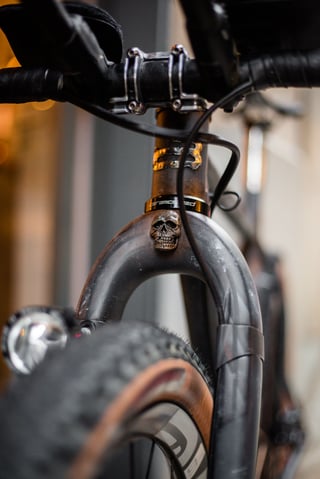 Skull head badge on the fork crown of the Belle Cycles A.T.E.R., below the CeramicSpeed headset and above the front tyre.