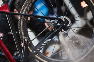 Pressure-washer spray hits a Canyon cyclocross bike's Dura-Ace brake rotor and muddy tyre at Hoogerheide.