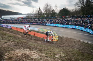Mathieu van der Poel and a rival ride a steep, muddy bank at the Hoogerheide Cyclocross World Cup before a packed crowd.