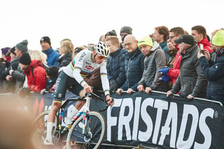 Mathieu van der Poel corners hard beside a packed fan barrier at the Hoogerheide Cyclocross World Cup.