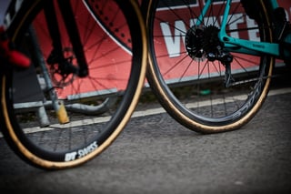 Tan-wall tyres on DT Swiss wheels, with the Shimano rear derailleur and disc brake of a turquoise cyclocross bike.