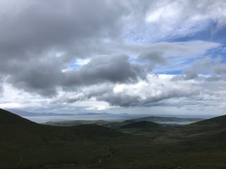 View from high ground over a bay and distant coast under heavy cloud, Dingle Peninsula, Kerry.