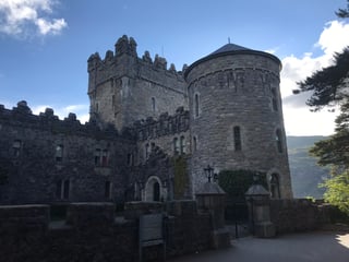 Grey stone towers and battlements of Glenveagh Castle in Glenveagh National Park, Donegal.