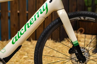 Alchemy script logo on the down tube and carbon fork of the E-Ronin e-gravel bike, with a gravel tyre and ENVE rim.