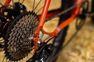 Close-up of the Breadwinner B-Road's rear dropout, wide-range cassette and chain on the orange steel frame.