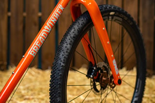 Breadwinner lettering on the orange down tube beside the ENVE fork and a knobbly gravel tyre on the B-Road.