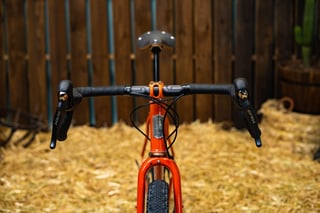 Breadwinner B-Road drop bars with Shimano GRX levers, an orange stem and a head badge, seen from the front.