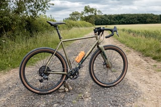 James Deane's Bombtrack Hook EXT gravel bike on a stony farm track with Teravail 650b tyres, side on.