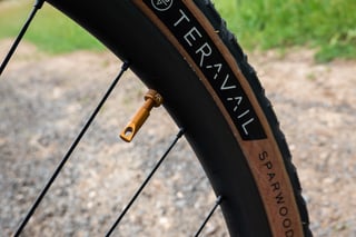Teravail Sparwood tyre on the Bombtrack Hook EXT, with a bourbon-coloured tubeless valve in the carbon rim.