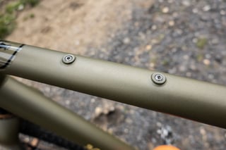 Two stainless grub screws in the matte olive top tube of James Deane's Bombtrack Hook EXT.