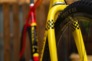 Yellow-painted fork with black checkerboard decals and a WTB tyre on the DeSalvo Gravel.