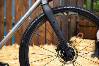 ENVE gravel fork and front wheel on the Moots Routt 45, with a disc brake and the Moots name on the titanium down tube.