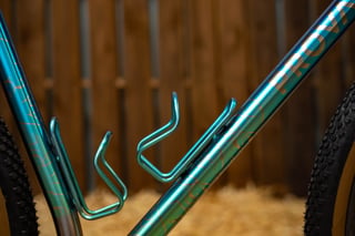 Two teal bottle cages colour-matched to the painted down tube of the Prova Cycles Mostro, with Prova lettering.