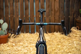 Prova Cycles Mostro seen head-on, with ENVE drop bars, teal logo accents and a knobbly front tyre below.