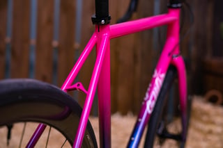 Slim pink seat stays and seat cluster on the SaltAir All-Road, with the paint fading to blue lower down.