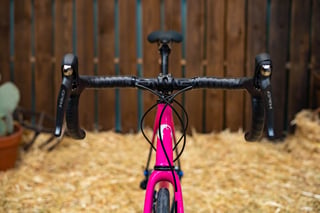 Front view of the SaltAir All-Road's drop bars with Shimano GRX levers and a pink head tube.