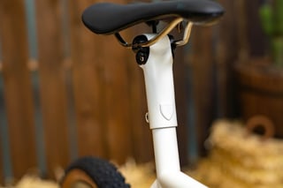 Speedvagen GTFO integrated seat mast and black saddle in cream paint, with the shield badge on the post.
