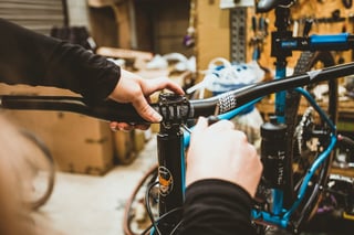 Hands tighten the short stem and Cotic flat bar on the Escapade, with a Hunt bottle on the frame.
