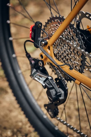 Rear dropout of the Fairlight Faran 2 with a SON rear dynamo light, GRX rear derailleur and wide-range cassette.