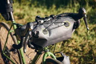 Apidura Expedition handlebar pack with yellow-edged hexagon patches and GRX brake levers on the Fairlight Faran.