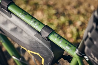 Apidura frame pack strapped to the green top tube of a Fairlight Faran 2, seen from above.