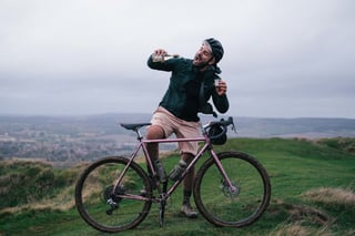 Stef from Pannier hams it up with the Muscat bottle and a cup astride his muddy pink Brother Kepler on the Wye Downs.