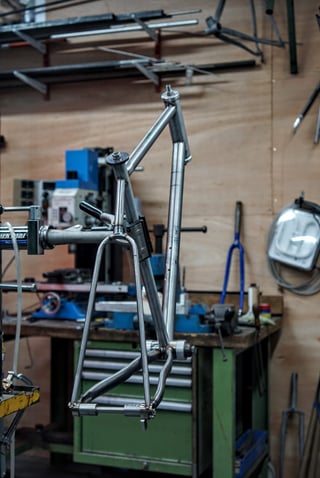 Bare steel gravel bike frame in a jig at the Stayer Cycles workshop in London.
