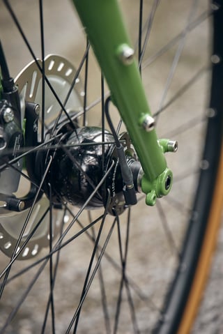 Dynamo front hub and thru-axle fork dropout on the Woodland Green Fairlight Faran 2 with a disc brake.